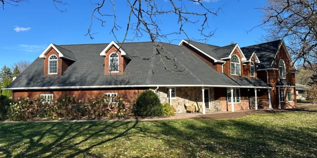 Finished roof replacement on a large home in western NY featuring dark architectural asphalt shingles
