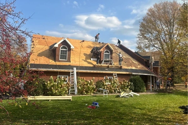 Roofing crew removing old shingles and installing a new roof on a residential home near Hamburg, NY