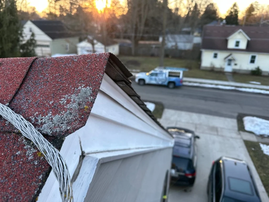Close-up of aging roof shingles and original eave before roof replacement in Hamburg, NY