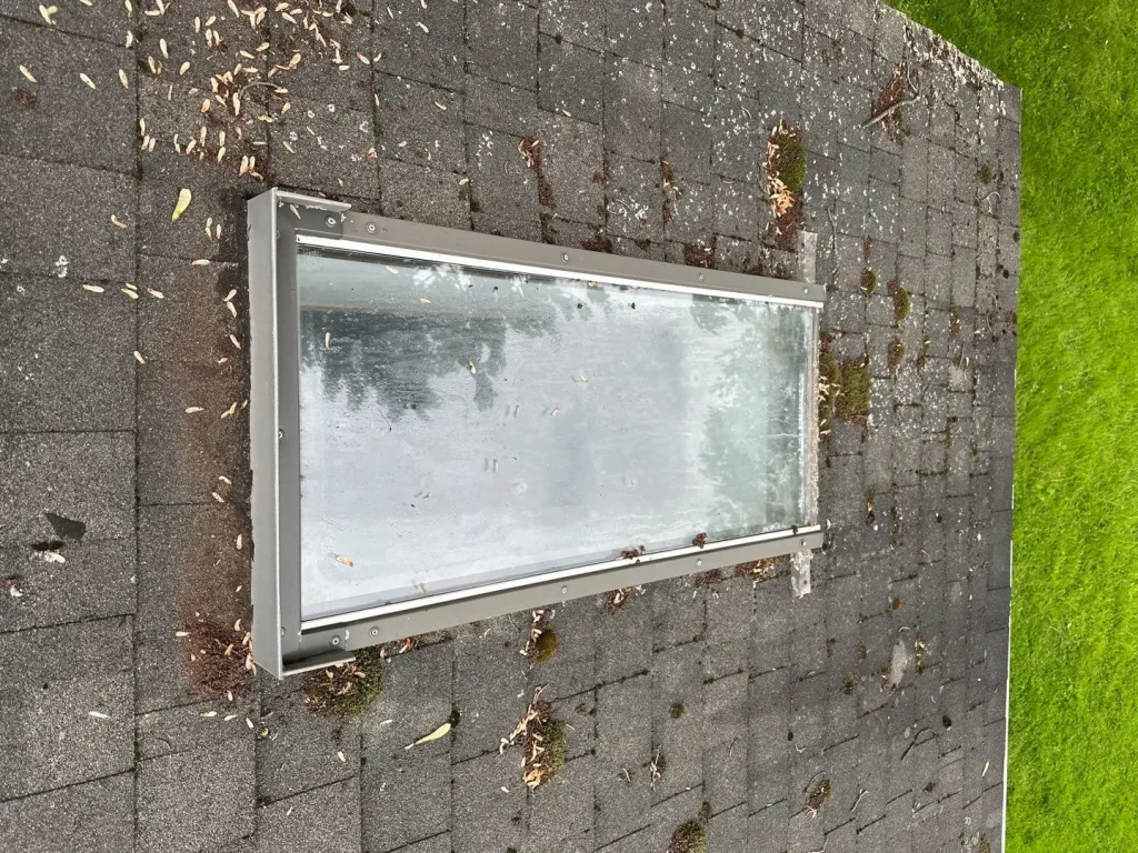 Existing skylight and asphalt shingles before skylight replacement at an Angola, NY home