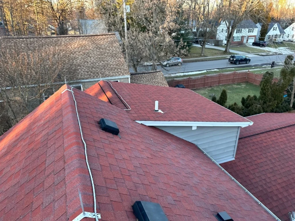 Before photo of red shingle roof and original roofline before eave reconstruction in Hamburg, NY