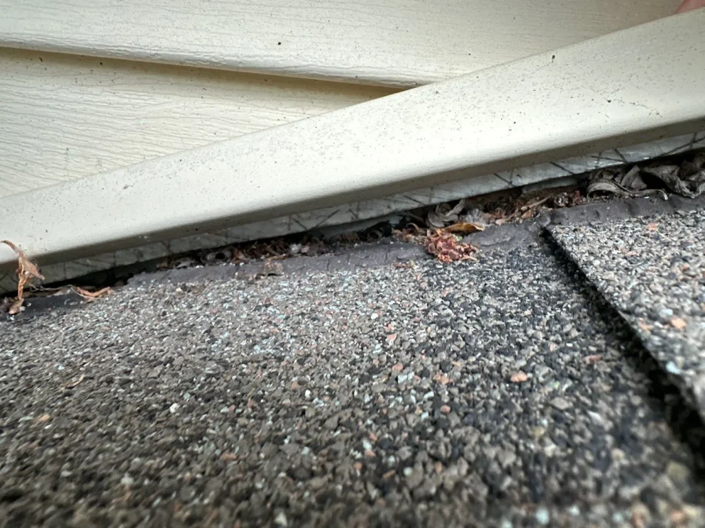 Close-up of the wall-to-roof transition before new step flashing and shingles were installed